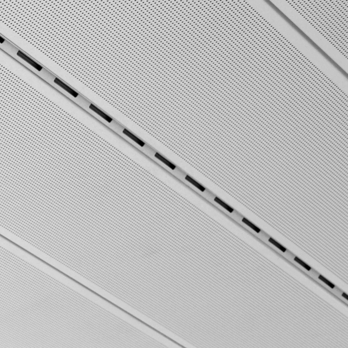 Detaliu macro: fantă liniară de ventilație vento între două casete perforate vektron